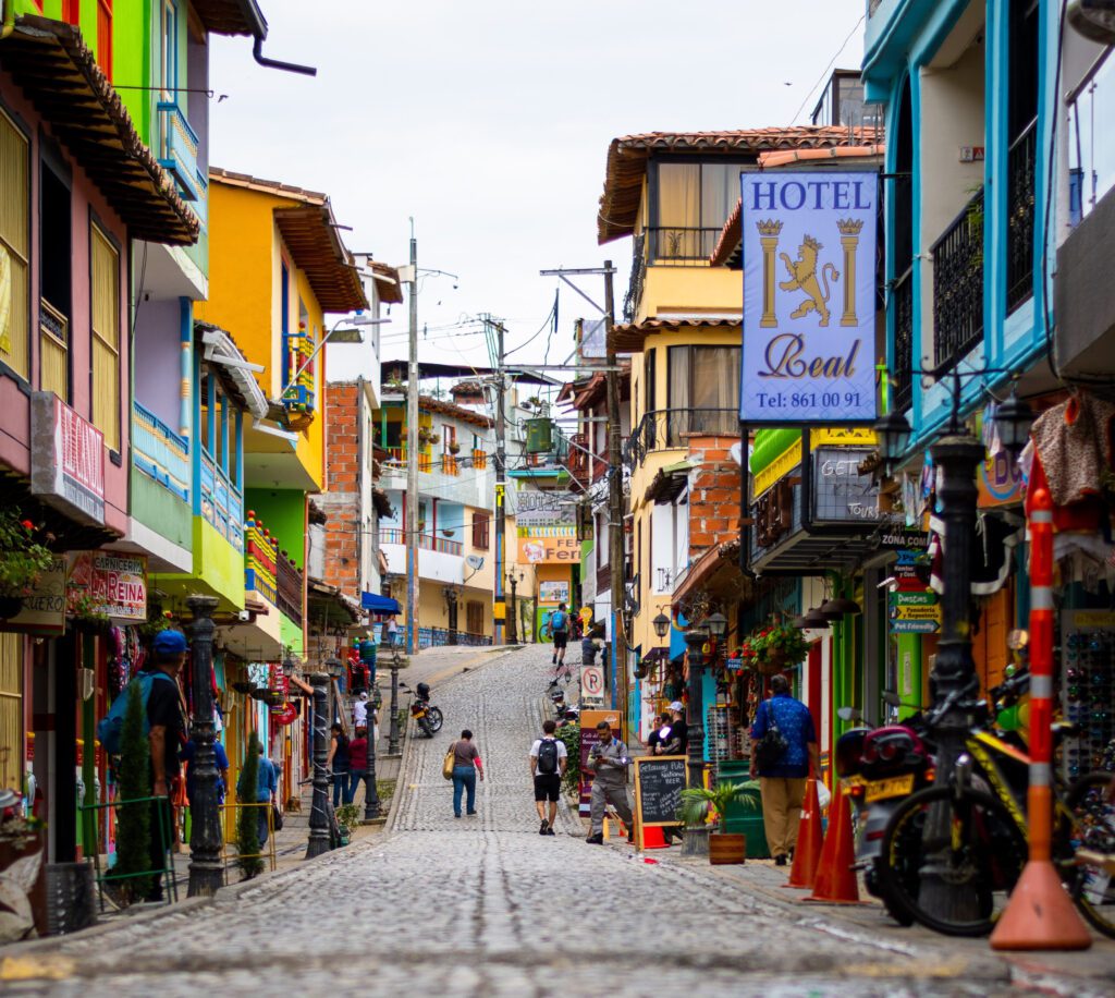 The vibrant streets of the rainbow-colored buildings of Guatapé, Colombia, with people walking through the street