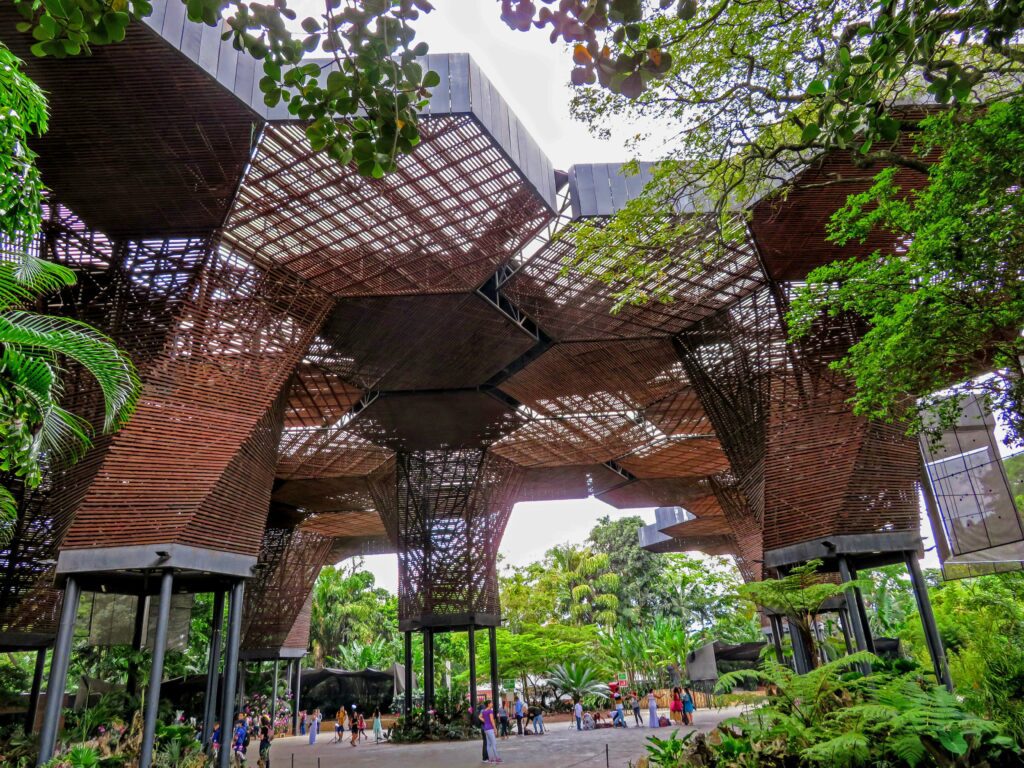 Image of the inside of the Medellín botanical garden featuring a large architectural structure known as the Orquideorama structure.