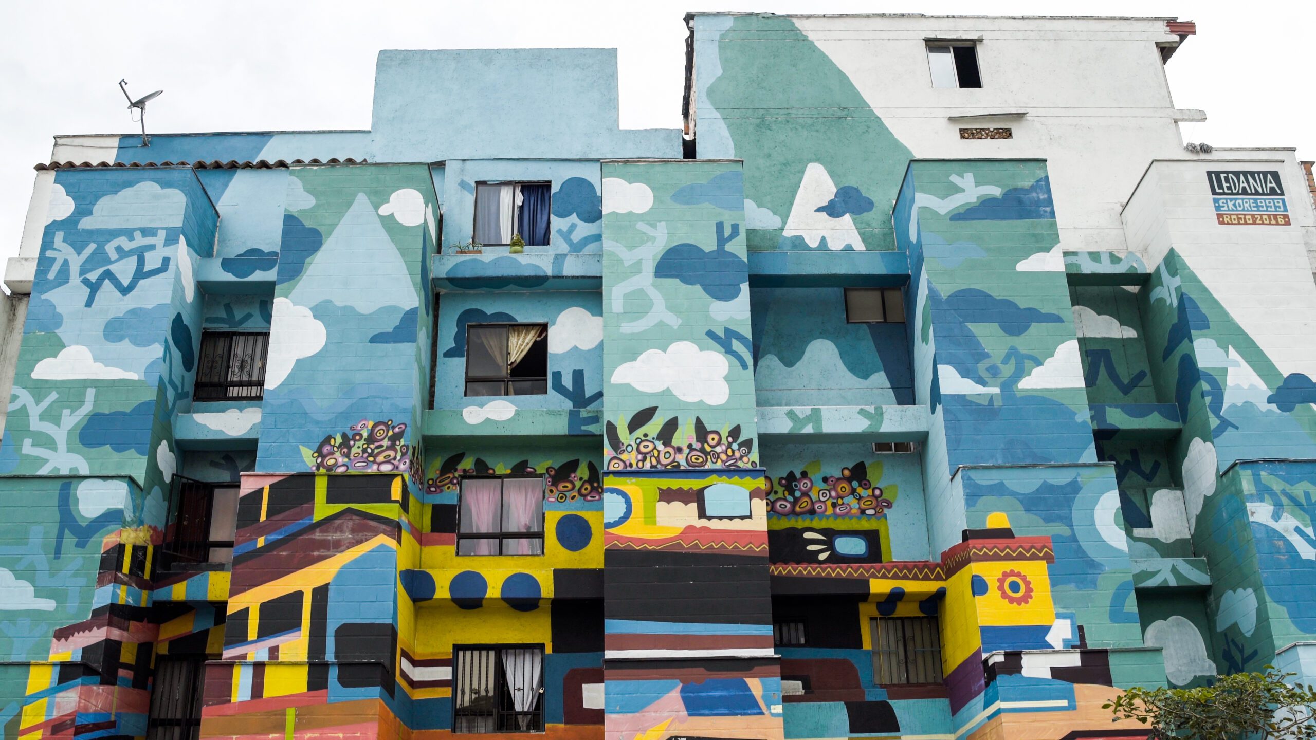 a multicolored building with a mural on the side of it.