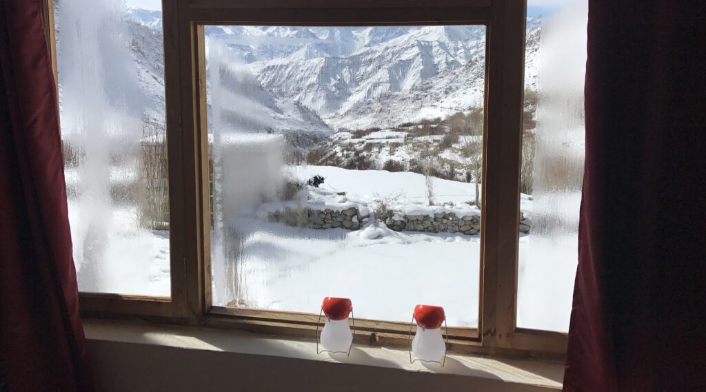 Window view of the snowy mountains of Leh at Snow Leopard Lodge, on a snow leopard safari Ladakh India in the Himalayas.