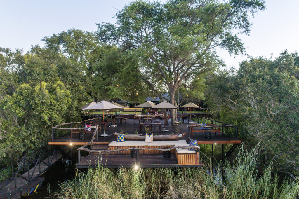 The sprawling riverside deck beneath a shade-giving indigenous tree strung with lights is an open invitation to gather, sip, and savor at the new Mukwa River Lodge.