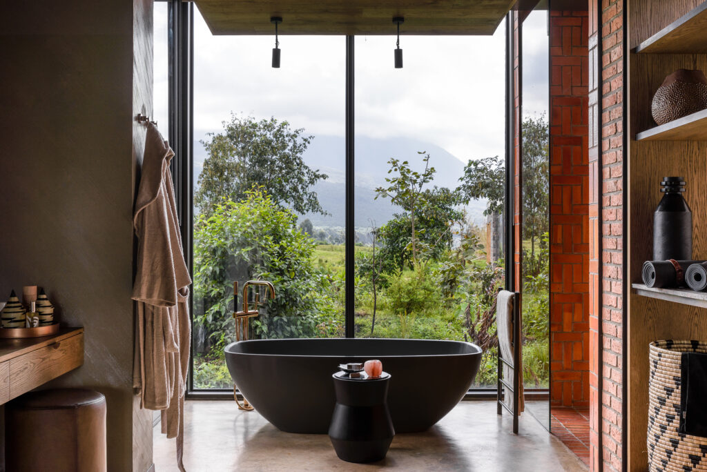  A bold ellipse tub is backdropped by dramatic views of steaming forest and volcanic peaks. Image courtesy of Singita