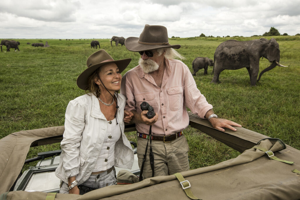 A couple on safari with an elephant in the background