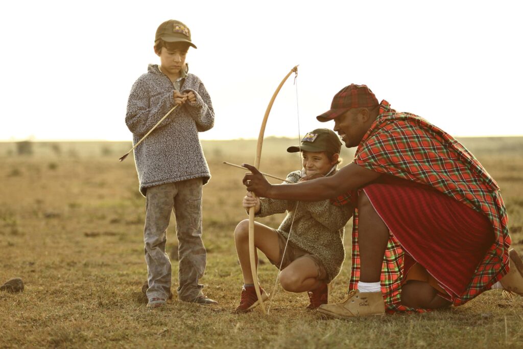 a man and two children with a bow in kenya