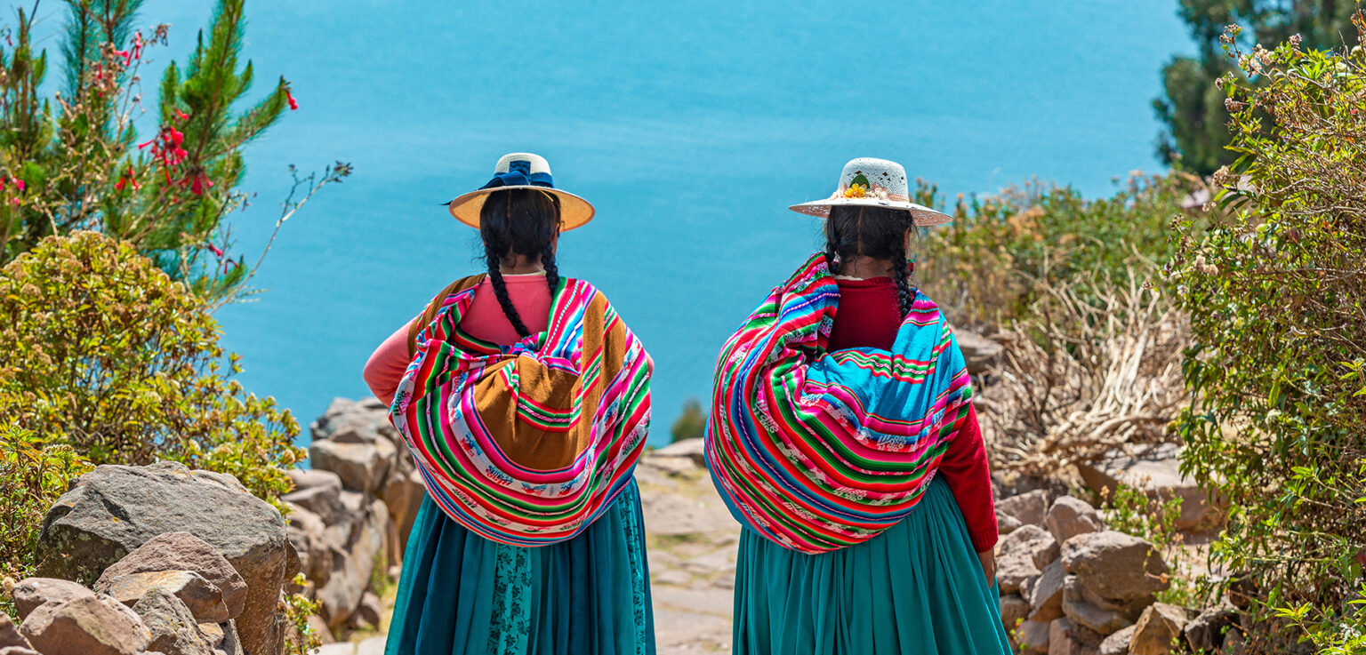 Two women in traditional clothes walking along path