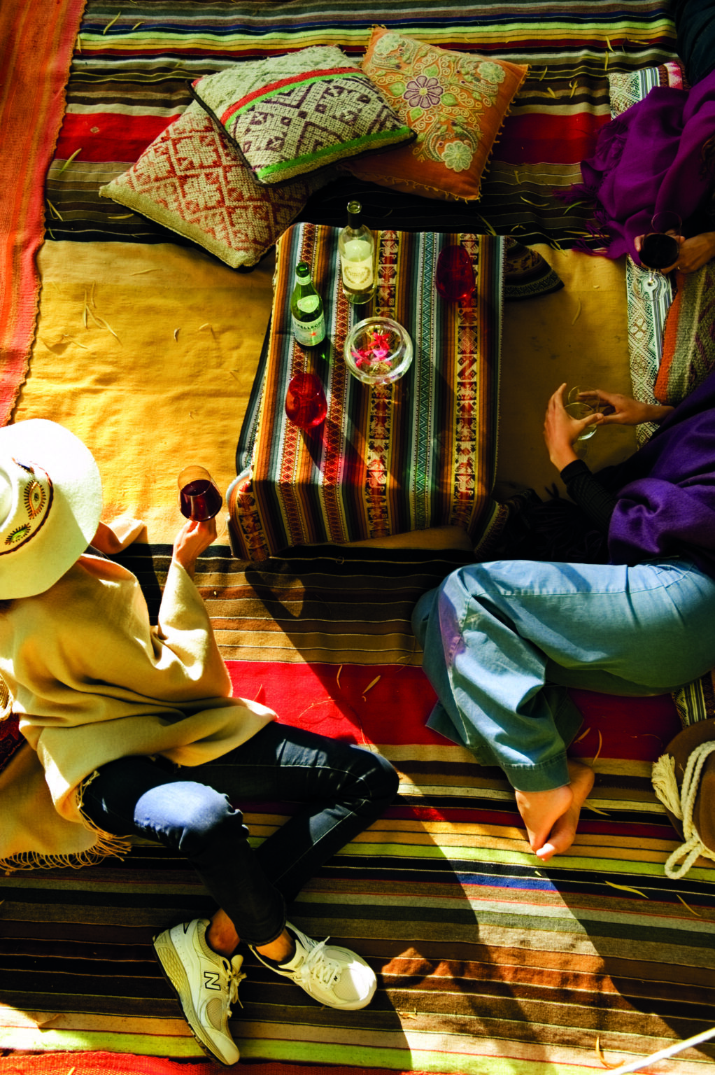 Two people lounging on colorful textiles