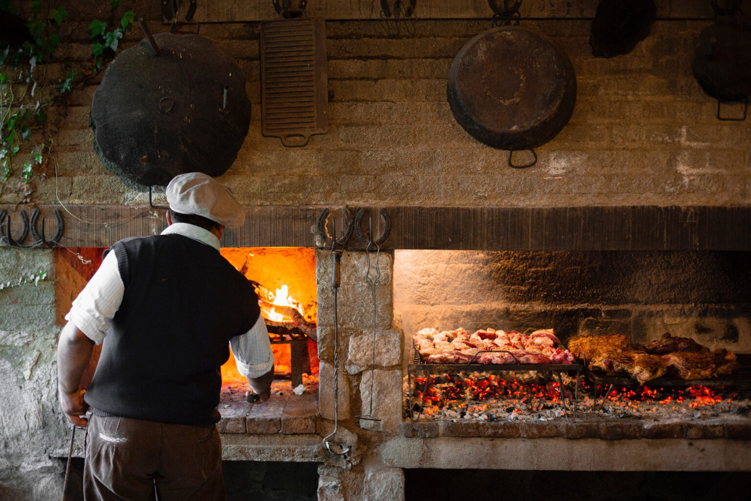 Man tending to typical Argentine parrilla grill