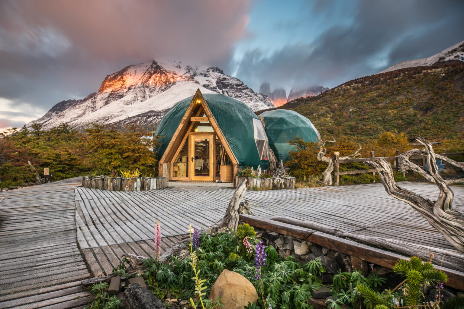Eco Camp dome with the wooden walkways in the foreground and mountains in the background
