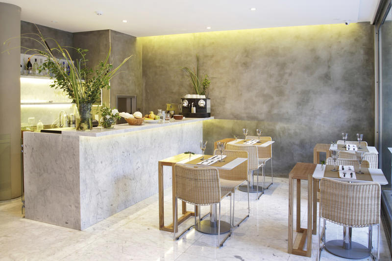 Breakfast room with concrete walls and four tables