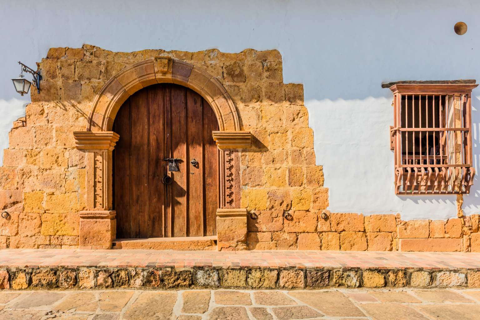 Arched wooden door on adobe house