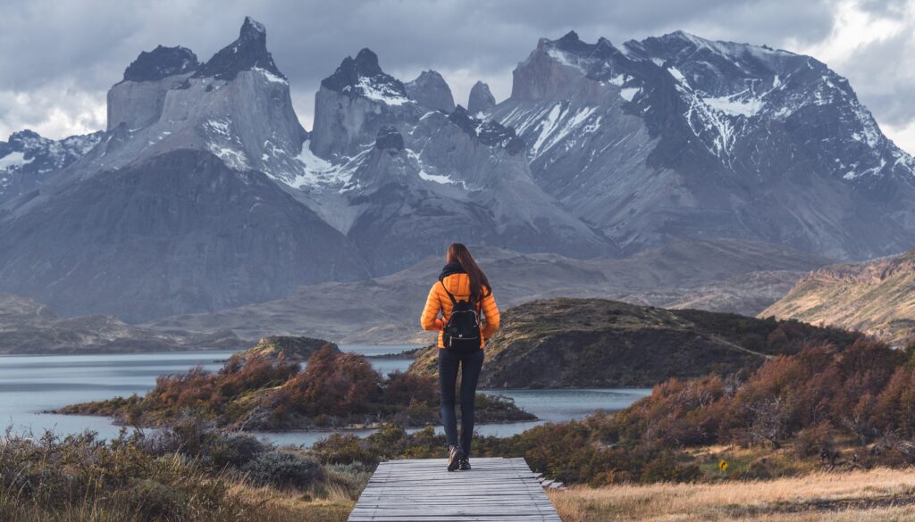 A hiker stands in front of Torres Del Pain's famous granite spires
