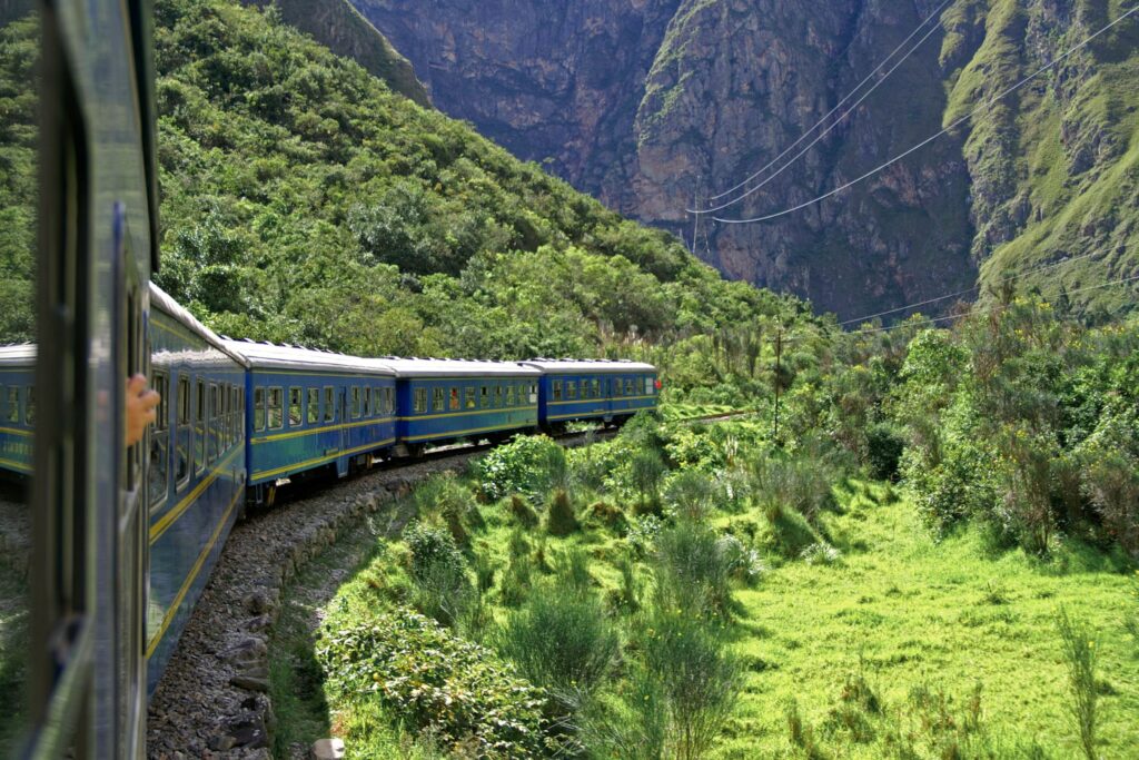 A blue train rolls along the tracks in Peru’s sacred valley
