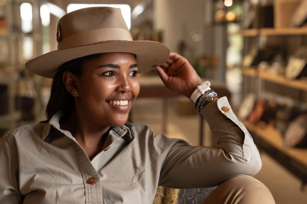A woman wearing a wide-rimmed safari hat in a safari lodge.