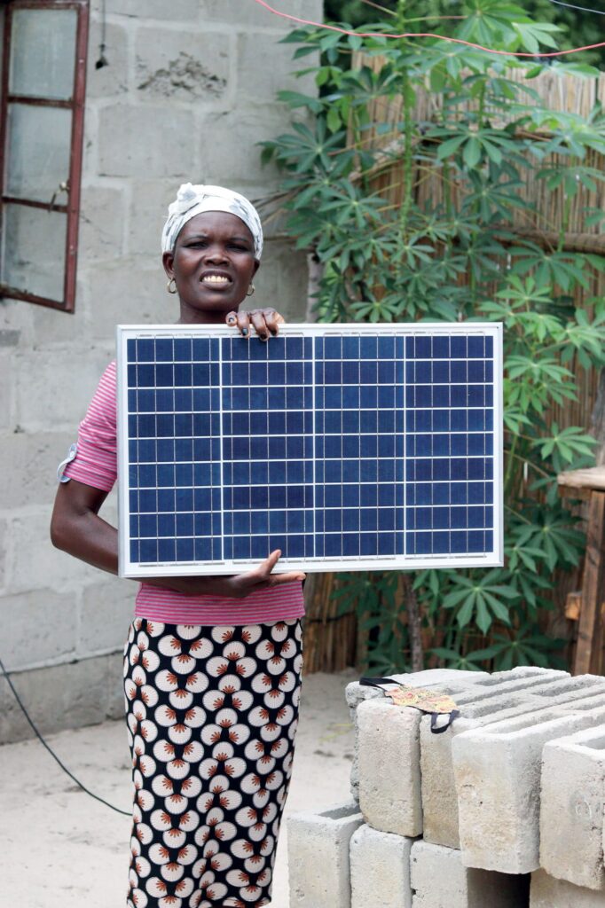 A woman, one of the Solar Mamas, holds a solar panel in Botswana