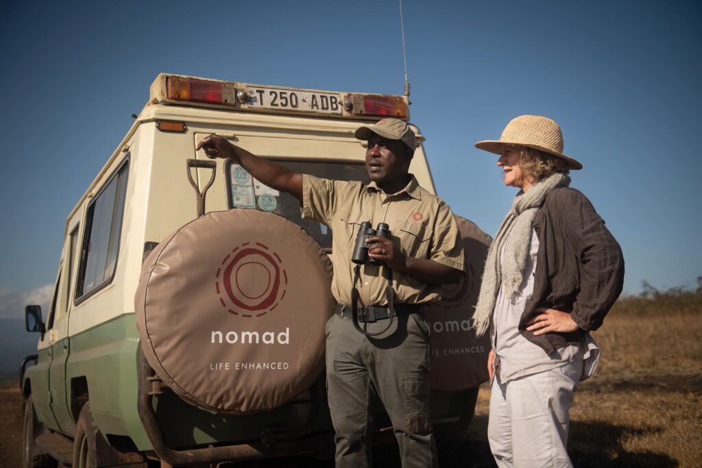 A Nomad guide explains something to a guest on safari in Tanzania