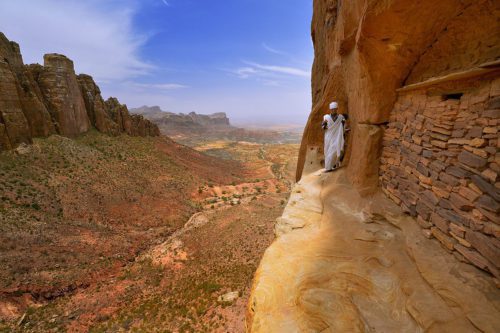 man walking along the edge of a cliff in Ethiopia