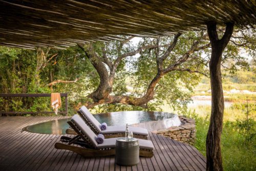 two chairs on a deck with a plunge pool looking out to the grass on our luxury safari in South Africa
