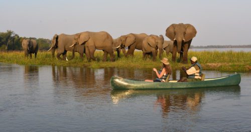 boat on the river with elephants in the background on Rwanda safari