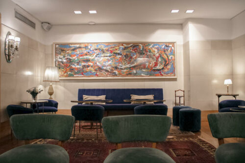 Hotel lobby with blue velvet couch and colorful painting