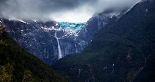 waterfall down a tall mountainside in aysen chile