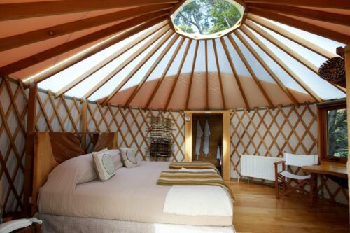 interior view of a patagonia camp yurt with white canvas stretched over brown timber beams
