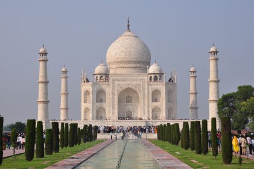 The Taj Mahal displaying perfect symmetry with landscaping and a reflecting pool in the foreground on India holiday